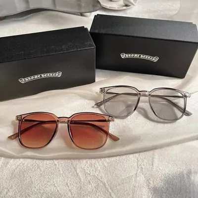 Two pairs of glasses, one with brown gradient lenses and one clear framed, laid beside their cases