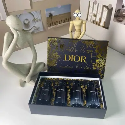 An open navy gift box holding four dark glass fragrance bottles on a shelf