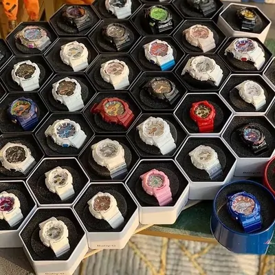Dozens of digital sports watches displayed upright in a honeycomb tray
